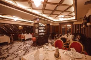 a restaurant with white tables and chairs and wine bottles at Hotel Chicago in Shkodër