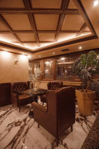 a living room with a table and chairs and a couch at Hotel Chicago in Shkodër