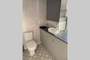 a bathroom with a toilet and a sink at Bellshill central apartments in Bellshill