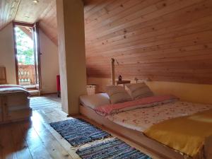 a bed in a room with a wooden wall at MOUNTAIN ECO CHALET KONJSKA DOLINA on 1400 m asl -near Pokljuka in Srednja Vas v Bohinju