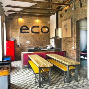 a restaurant with two wooden benches in a room at ECO Hostel in Granada