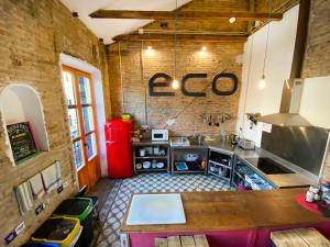 a kitchen with a counter and a red refrigerator at ECO Hostel in Granada