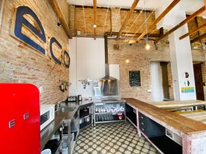 a large kitchen with a counter and a brick wall at ECO Hostel in Granada