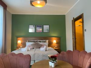1 dormitorio con paredes verdes y 1 cama con 2 sillas en DW California en Rewal