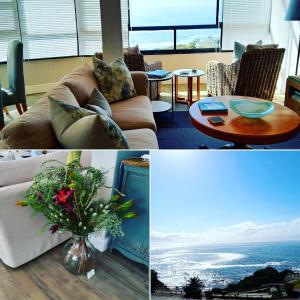 a living room with a couch and a table with a vase of flowers at The Sun,Whales and Waves seafront apartment in Hermanus