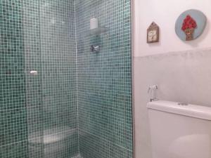 bagno con servizi igienici e doccia piastrellata verde di Chalé Gostosomar a São Miguel do Gostoso