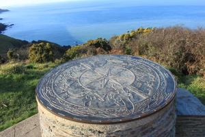 a stone box with a symbol on it with the ocean at The Olive Branch in Ilfracombe