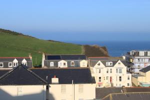 a group of houses with the ocean in the background at The Olive Branch in Ilfracombe