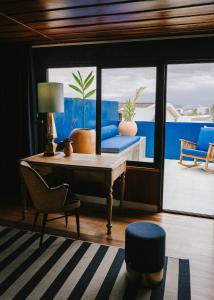 Habitación con escritorio, sillas y ventana. en Casa 41, en Escazú