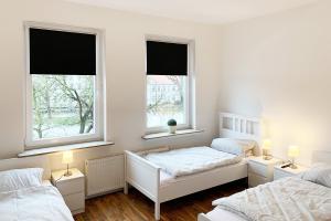 2 camas en una habitación con 2 ventanas en Moderne 3 Zimmer Ferienwohnung, en Celle