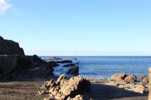 a beach with rocks and the ocean in the background at The Olive Branch in Ilfracombe