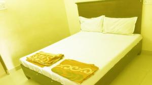 a bedroom with a bed with gold sheets and pillows at Vishnu Residency Warangal in Warangal