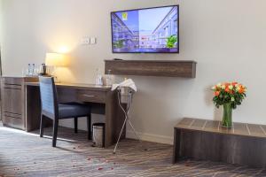 a room with a desk and a television on a wall at Eka Hotel Eldoret in Eldoret