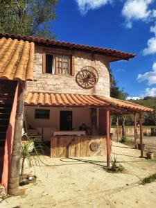 uma casa com um relógio ao lado dela em Espaço João Mineiro em Tiradentes