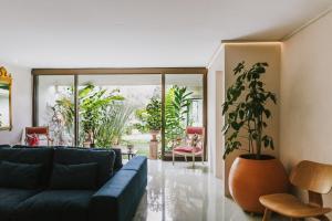 uma sala de estar com um sofá azul e um vaso de plantas em Casa 41 em Escazú