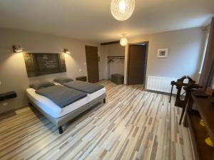 1 dormitorio con 1 cama y suelo de madera en L’Été en Novembre, en Kirrwiller
