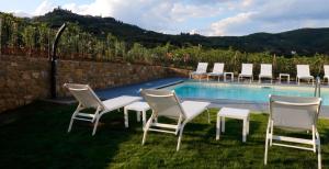 a group of chairs sitting next to a swimming pool at Podere La Doccia in Civitella in Val di Chiana