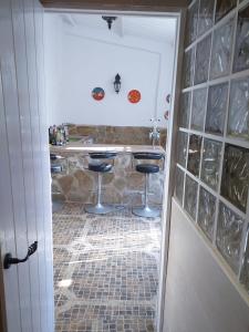 eine Küche mit einer Theke und Stühlen auf einem Fliesenboden in der Unterkunft Casa De Royal Oaks in Encinas Reales