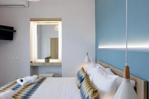 una camera da letto con un letto con una parete blu di Seaside Palette Suites a Rethymno
