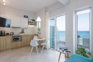 una cucina con tavolo, sedie e l'oceano di Seaside Palette Suites a Rethymno