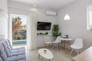 un soggiorno con un divano, un tavolo e delle sedie di Seaside Palette Suites a Rethymno
