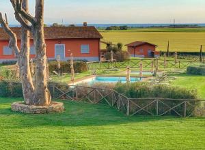 a house with a pool in the middle of a field at Agriturismo Piani Della Marina in Montalto di Castro