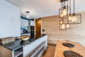 a kitchen with a black counter and a wooden table at Apartment Wapa Alpe d'Huez - by EMERALD STAY in L'Alpe-d'Huez