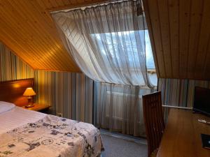 1 dormitorio con 1 cama y una ventana con cortinas en Atlanta Sheremetyevo Hotel, en Sheremétievo