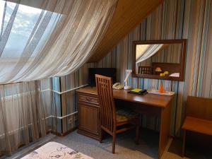 a desk with a mirror and a chair in a room at Atlanta Sheremetyevo Hotel in Sheremetyevo
