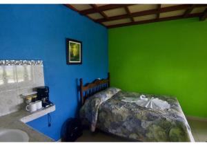a bedroom with a bed and a green wall at Cabinas Los Tucanes Private Room #4 with Volcano view in Fortuna +14 photos