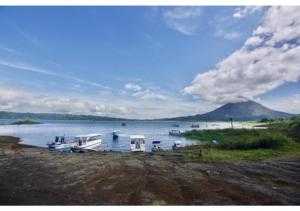 a group of boats docked on the shore of a lake at Cabinas Los Tucanes Private Room #4 with Volcano view in Fortuna