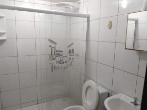Baño blanco con aseo y lavamanos en Aruanda Guest House, en Salvador