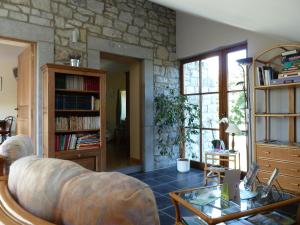 un salon avec un canapé et un mur en pierre dans l'établissement Le Clos Marie, à Ciney