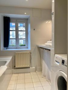 ein Bad mit einer Waschmaschine und einem Fenster in der Unterkunft Le Gîte in Senlis