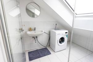 La salle de bains est pourvue d'un lave-linge et d'un lavabo. dans l'établissement 2 Zimmer Apartment mit Balkon, à Büsingen