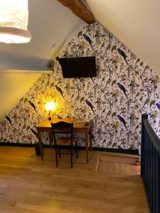 a dining room with a table and a tv on a wall at Le Gîte in Senlis
