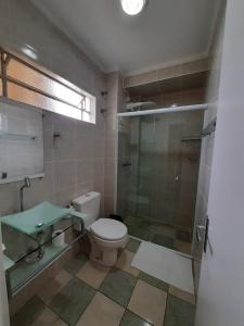 a bathroom with a toilet and a glass shower at Esplanada Hotel in Sao Paulo