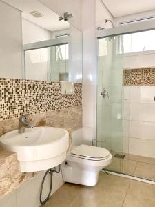 ein Bad mit einem Waschbecken, einem WC und einer Dusche in der Unterkunft Apartamento em Holambra in Holambra