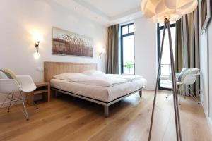 ein Schlafzimmer mit einem Bett mit einer Leiter und Stühlen in der Unterkunft Villa Claire meerZEIT in Ostseebad Sellin