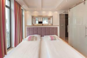 ein Schlafzimmer mit einem großen Bett und einem Spiegel in der Unterkunft Villa Claire meerZEIT in Ostseebad Sellin
