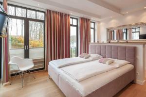 ein großes Schlafzimmer mit einem großen Bett und einem Stuhl in der Unterkunft Villa Claire meerZEIT in Ostseebad Sellin
