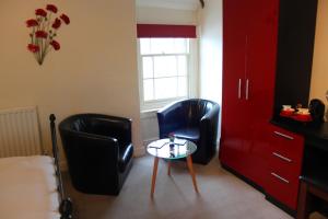two black chairs and a table in a bedroom at The Olive Branch in Ilfracombe