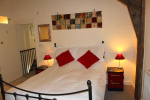 a bedroom with a bed with two red pillows at The Olive Branch in Ilfracombe