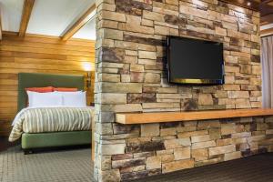 a bedroom with a stone wall with a flat screen tv at Comfort Inn The Pointe in Niagara Falls