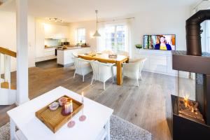 eine Küche und ein Wohnzimmer mit einem Tisch und einem Kamin in der Unterkunft Ferienhaus Strandhafer in Wangerooge