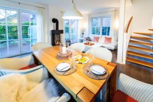 Ferienhaus Strandhafer في فانجر أوخه: غرفة معيشة مع طاولة وكراسي خشبية