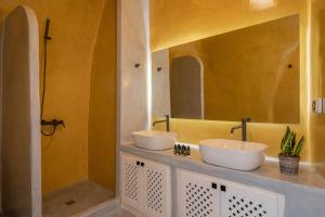 a bathroom with two sinks and a shower at Ecolodge Cave House in Vóthon