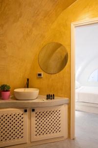 a bathroom with a sink and a mirror on the wall at Ecolodge Cave House in Vóthon