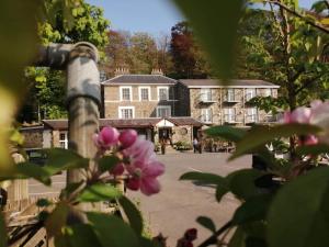 a view of a building with pink flowers in the foreground at Three Rivers Hotel in Ferryside