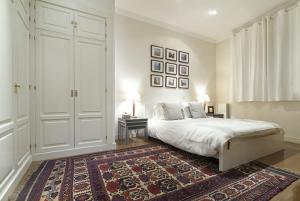 een witte slaapkamer met een bed en een tapijt bij Apartamento Principe Terrace en Madrid in Madrid